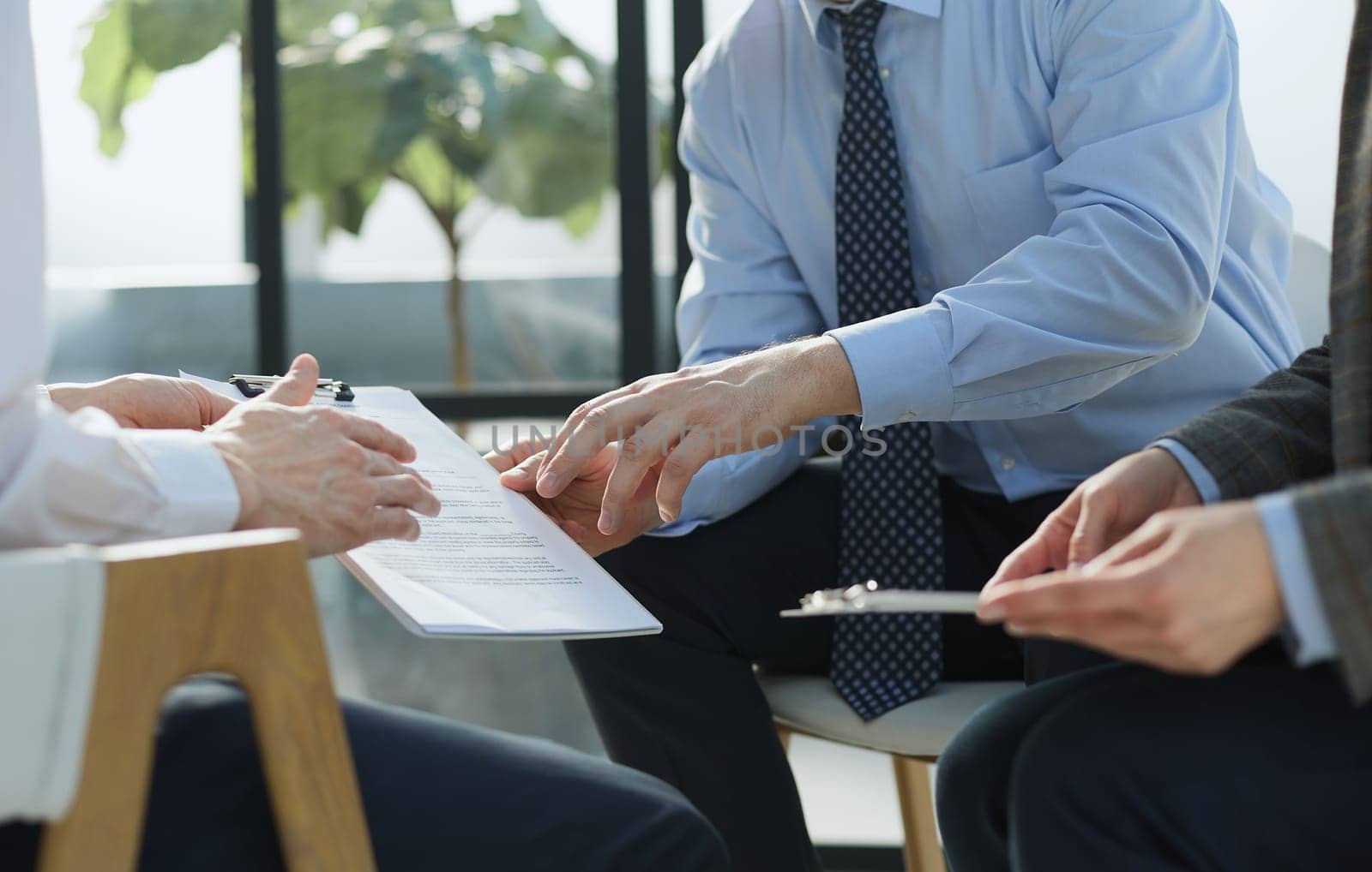 Two business employees reviewing documents in open folder.