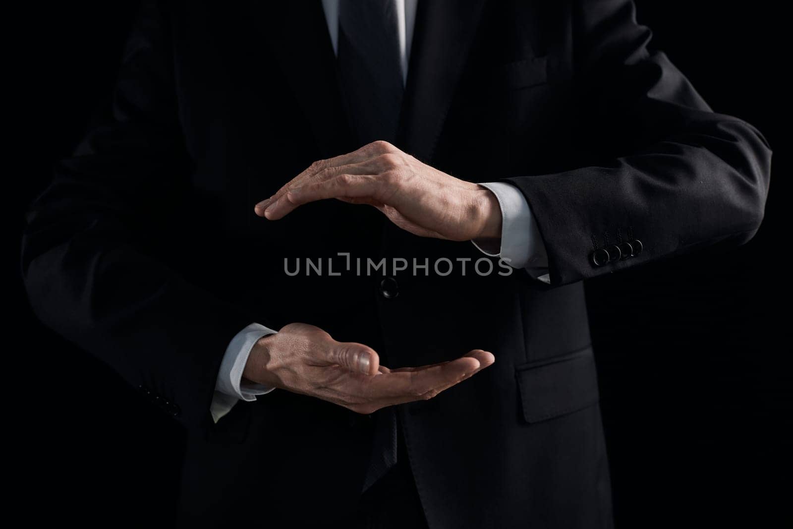 A pair of male hands holding a virtual earth on a black background