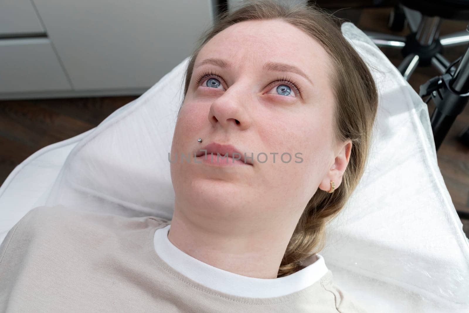 Portrait Of Young Caucasian Woman After Eyelash Lamination Procedure, Lash Treatment Lying on Couch. Horizontal Plane High quality photo.