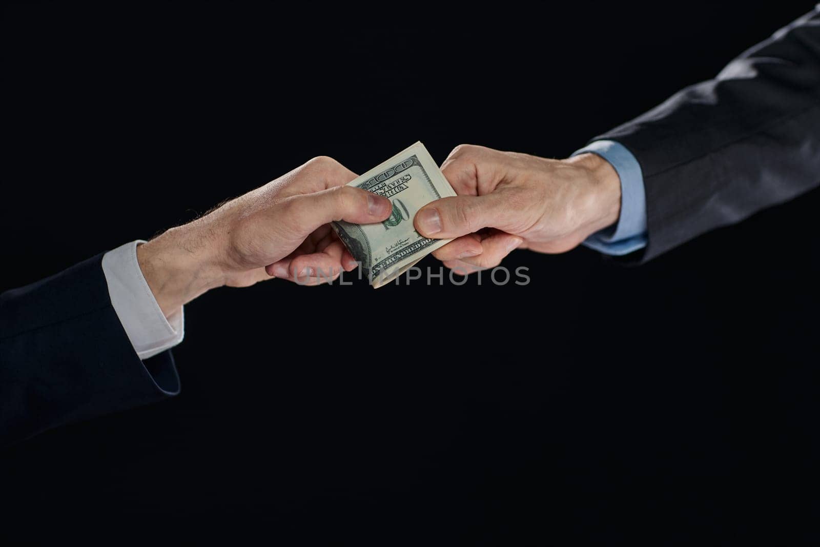 few bills in his hand on a dark background. Copyspace.
