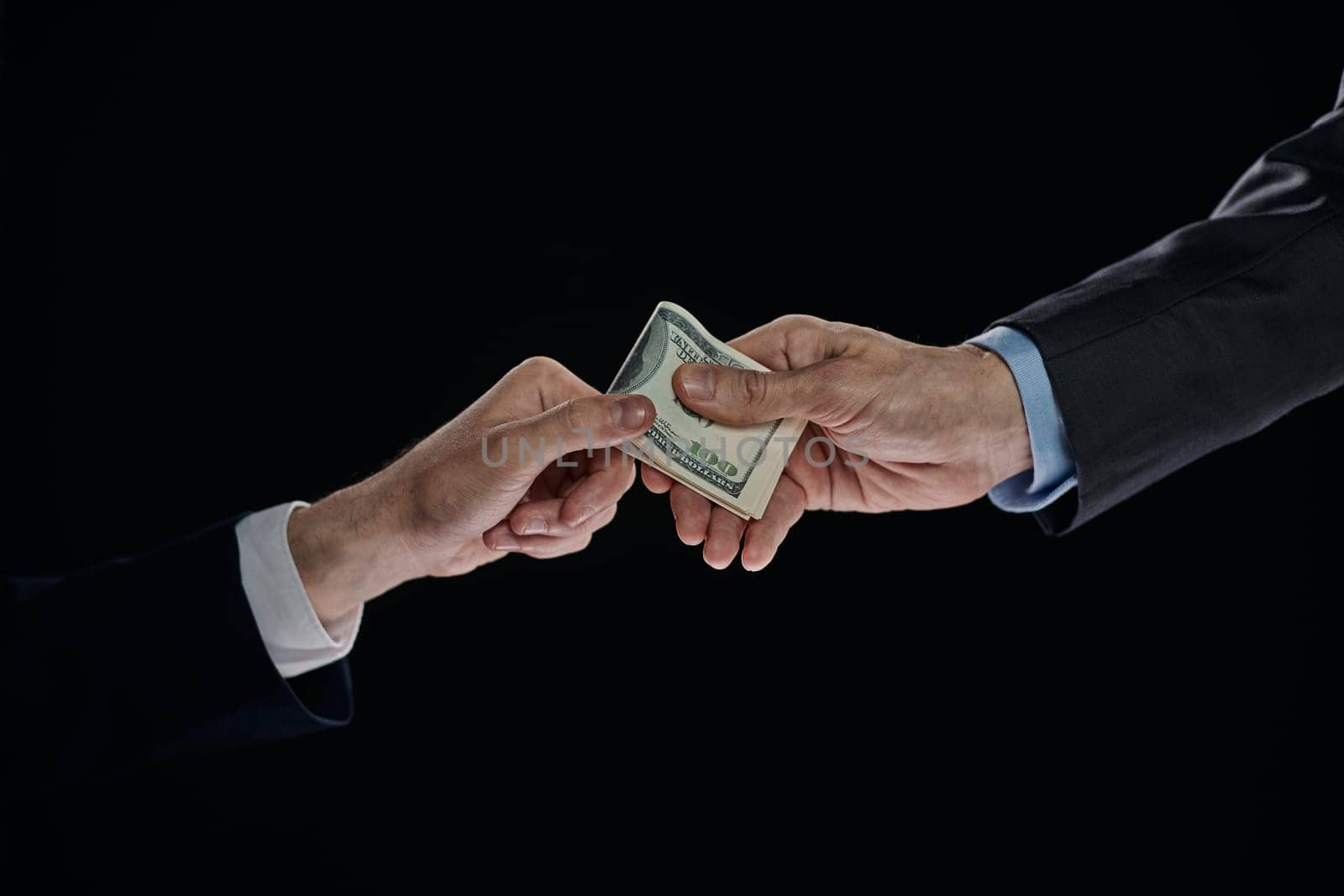few bills in his hand on a dark background. Copyspace.