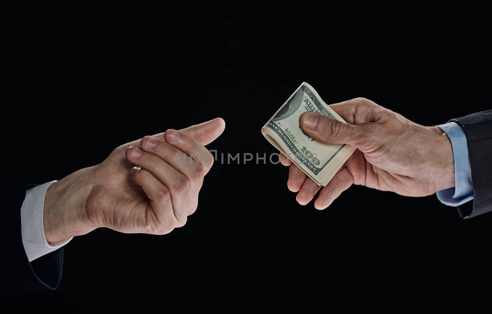 few bills in his hand on a dark background. Copyspace.