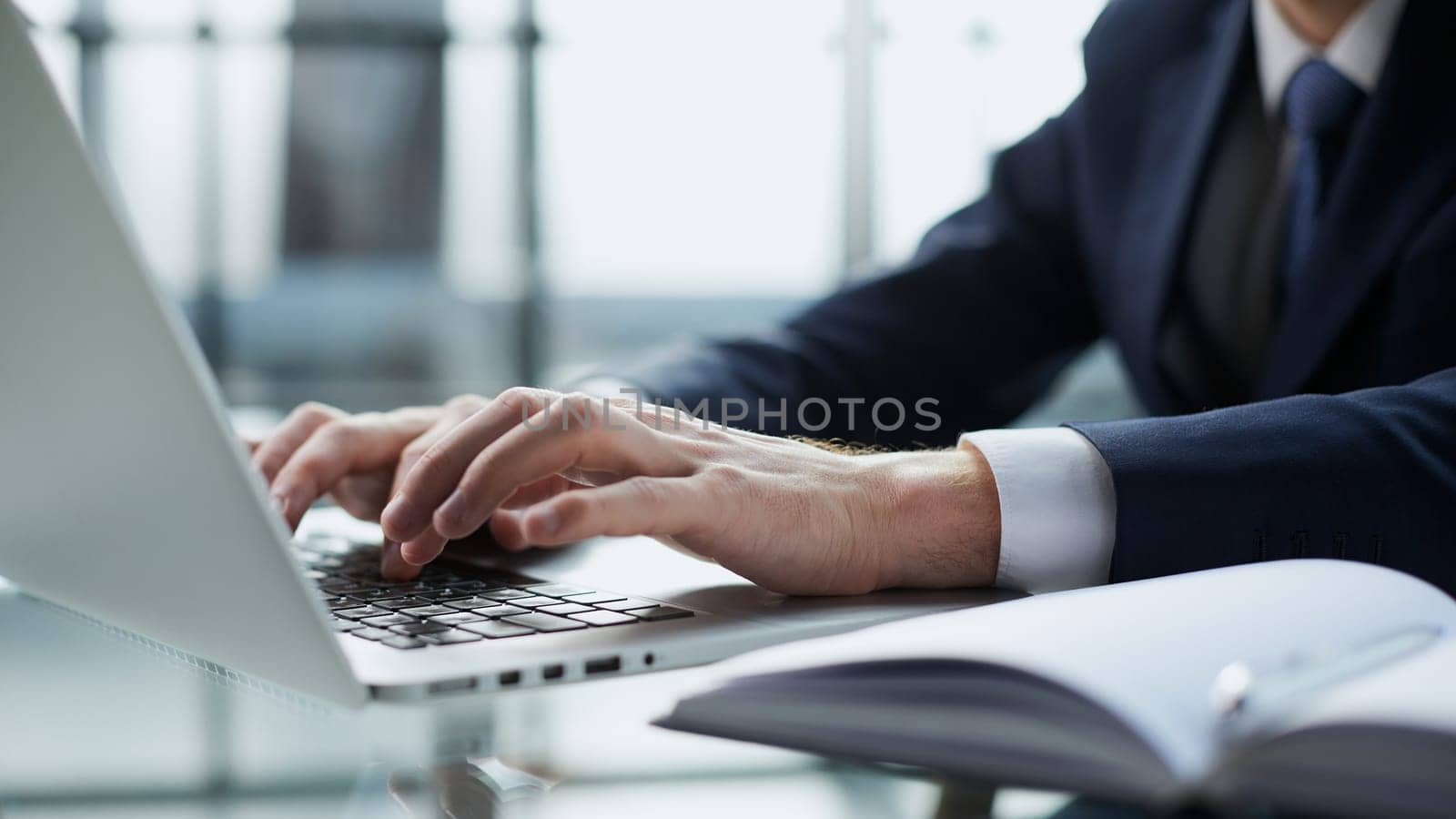 Young man working on computer at table in office, closeup. Banner design