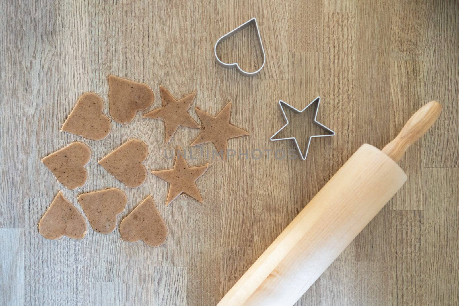 Preparing bakery in kitchen, homemade Christmas ginger bread cookies with rolling pin and kitchen utensil, Xmas gingerbread cookie on wooden tray, process of baking and cooking at home