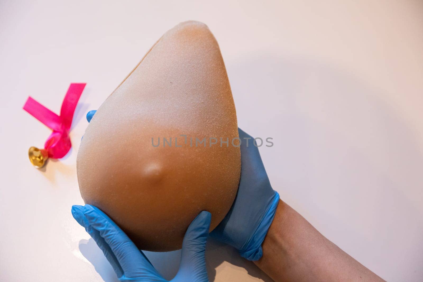 Demonstration of how to examine your breast with one hand on the phantom of Lady M. Professional demonstration of breast compression technique during the examination.