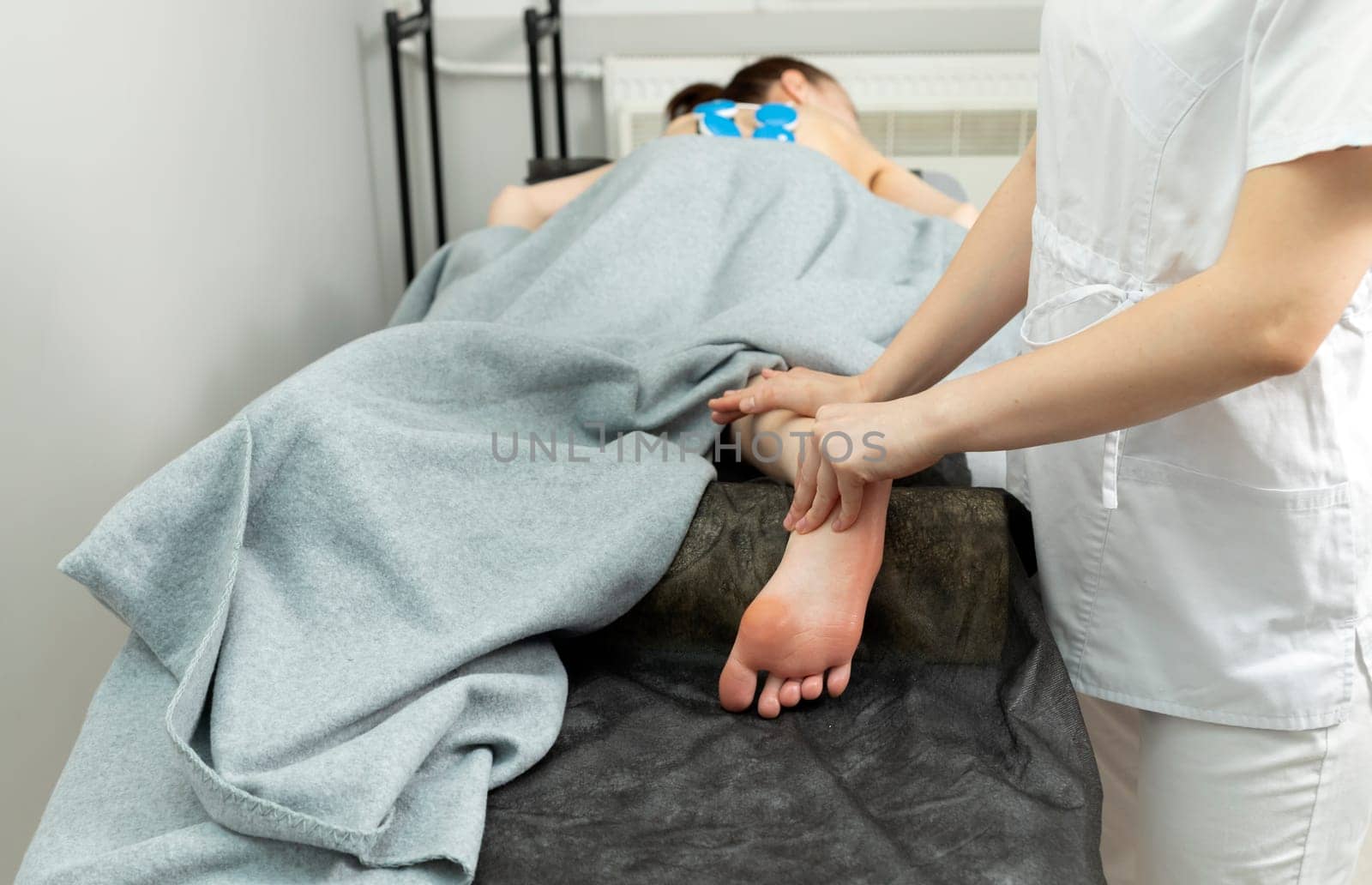Rehabilitation Specialist, Physical Therapist Makes Foot Massage To Patient With Cerebral Palsy, Scoliosis. Health Specialist, Rehabilitation. Horizontal plane. High quality photo
