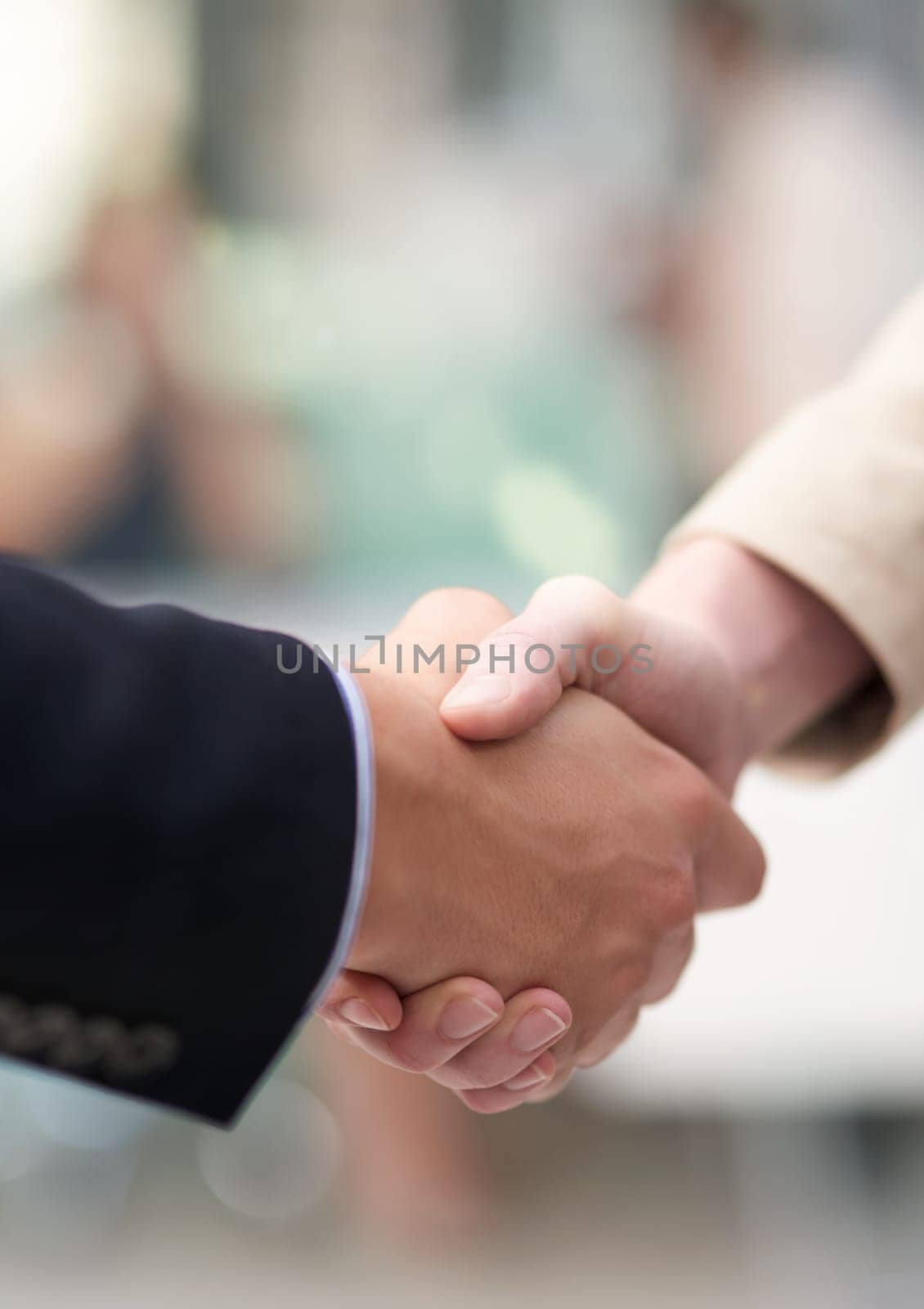 Business meetings. Shot of a coworkers shaking hands in an office. by YuriArcurs