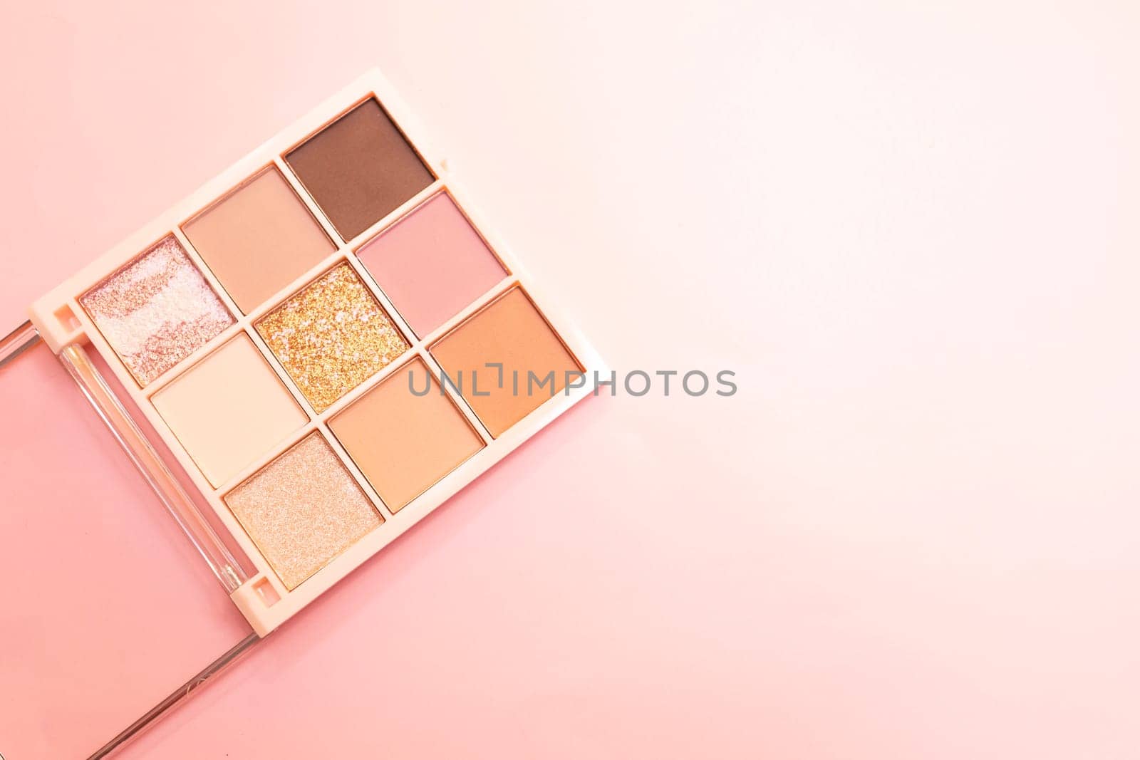 Eyeshadow multicolored palette cosmetics for eyes, face on pink background. Minimalism makeup, delicate shades. Copy space for text on right side, horizontal plane, flat lay. High quality photo