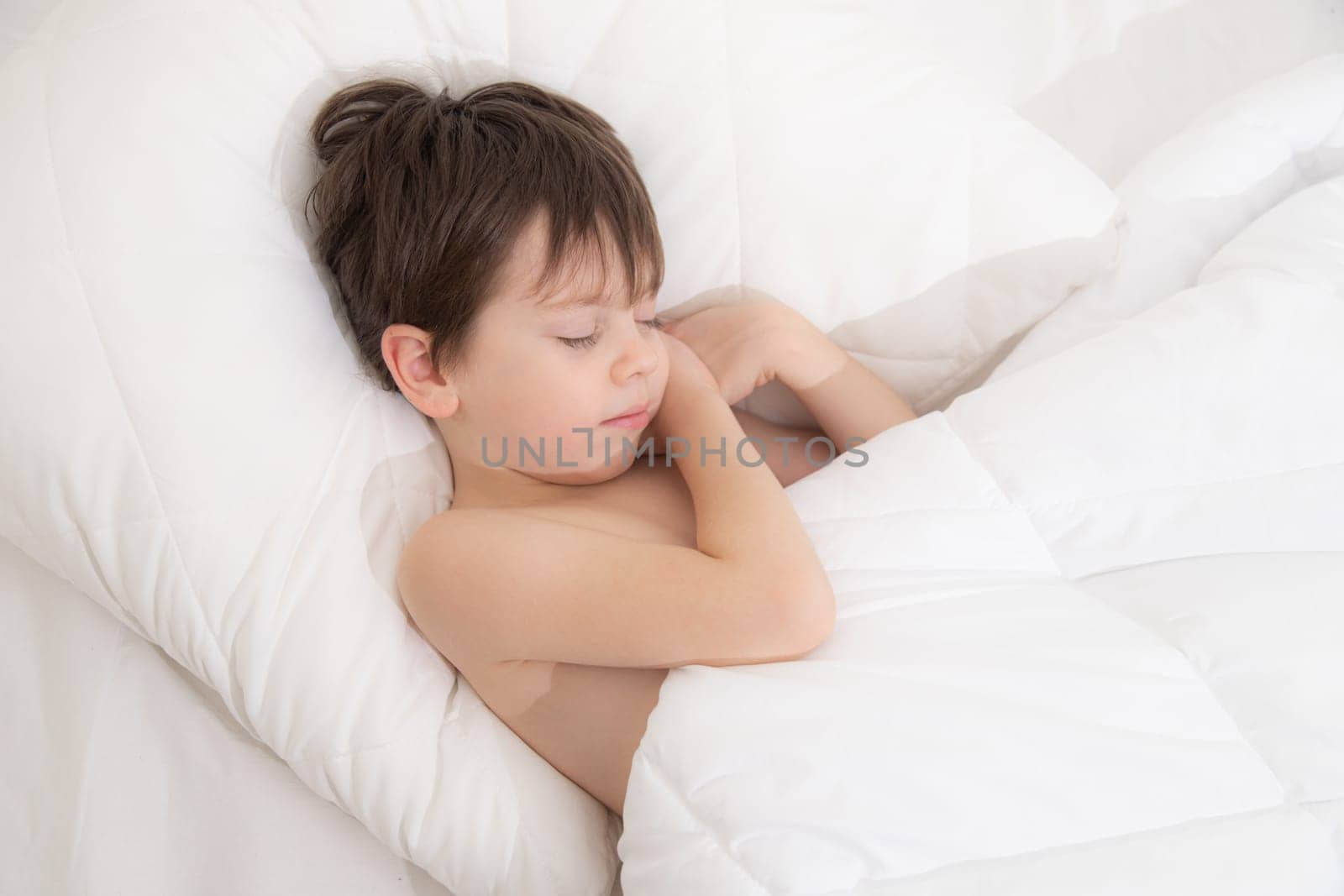 The child is sleeping sweetly in his bed . Sweet baby's dream. The child is in bed . An article about children's dreams. Boy