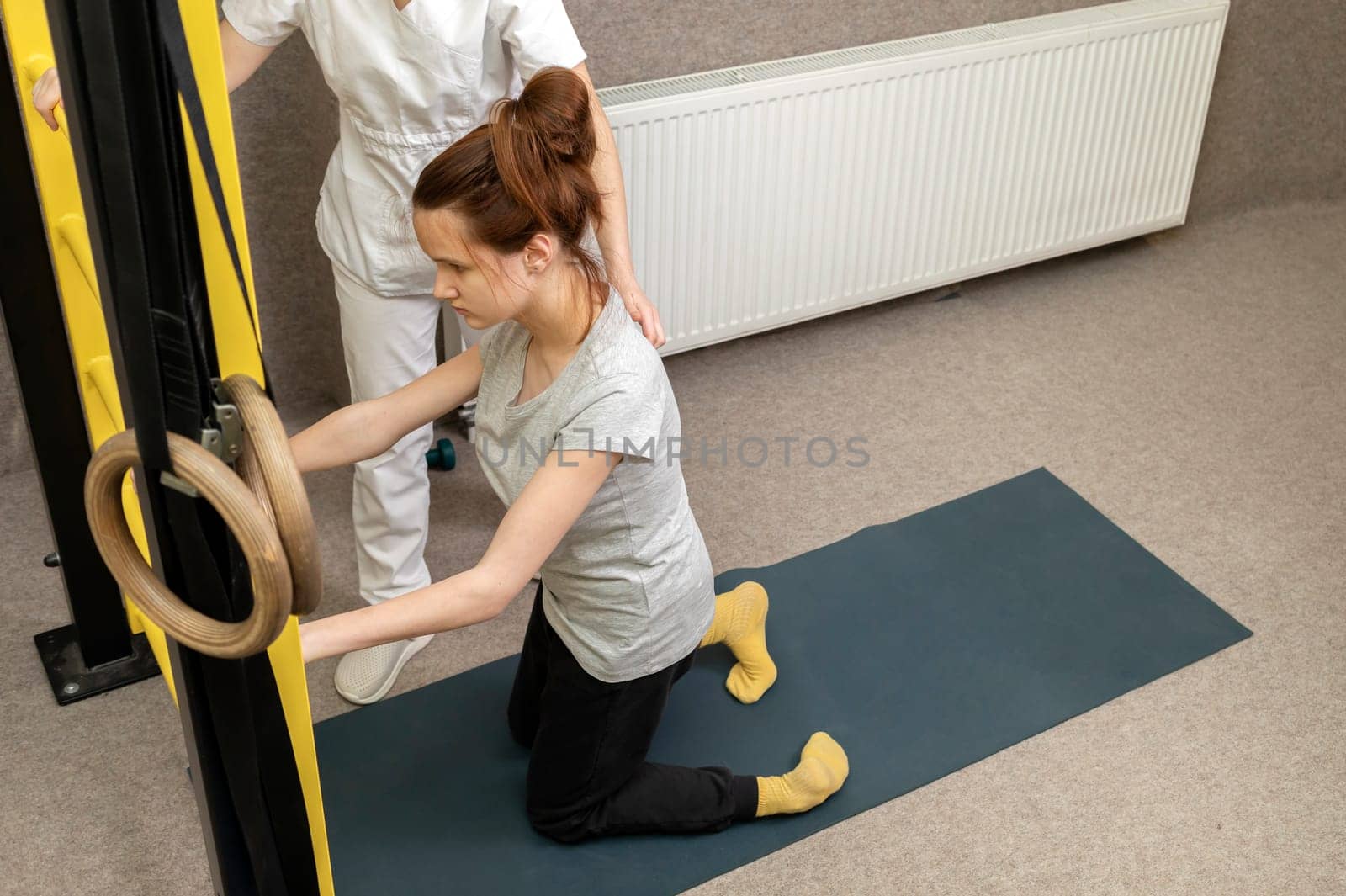 Disabled Child With Physician Does Physical Exercises In Gym. Kid With Special Needs. Rehabilitation. Cerebral Palsy. Motor Disorder. Horizontal plane. High quality photo
