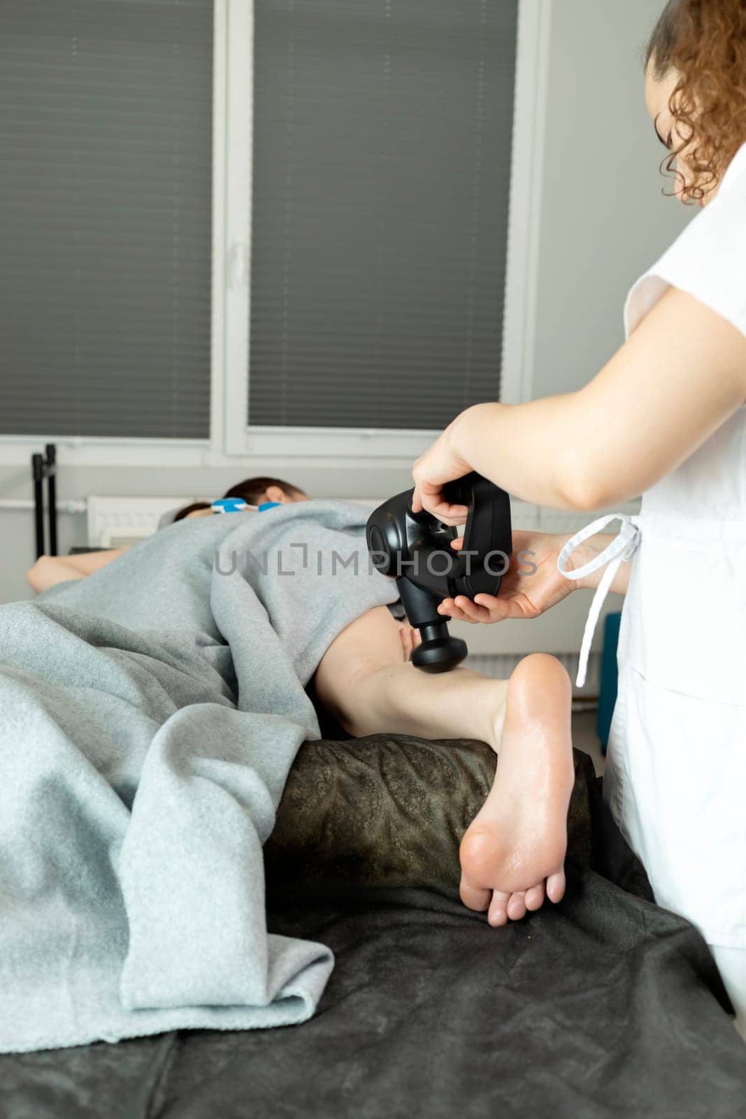 Rehabilitation Specialist, Physical Therapist Makes Leg Massage To Child With Cerebral Palsy, Scoliosis. Health Specialist, Rehabilitation. Vertical plane. Close up.