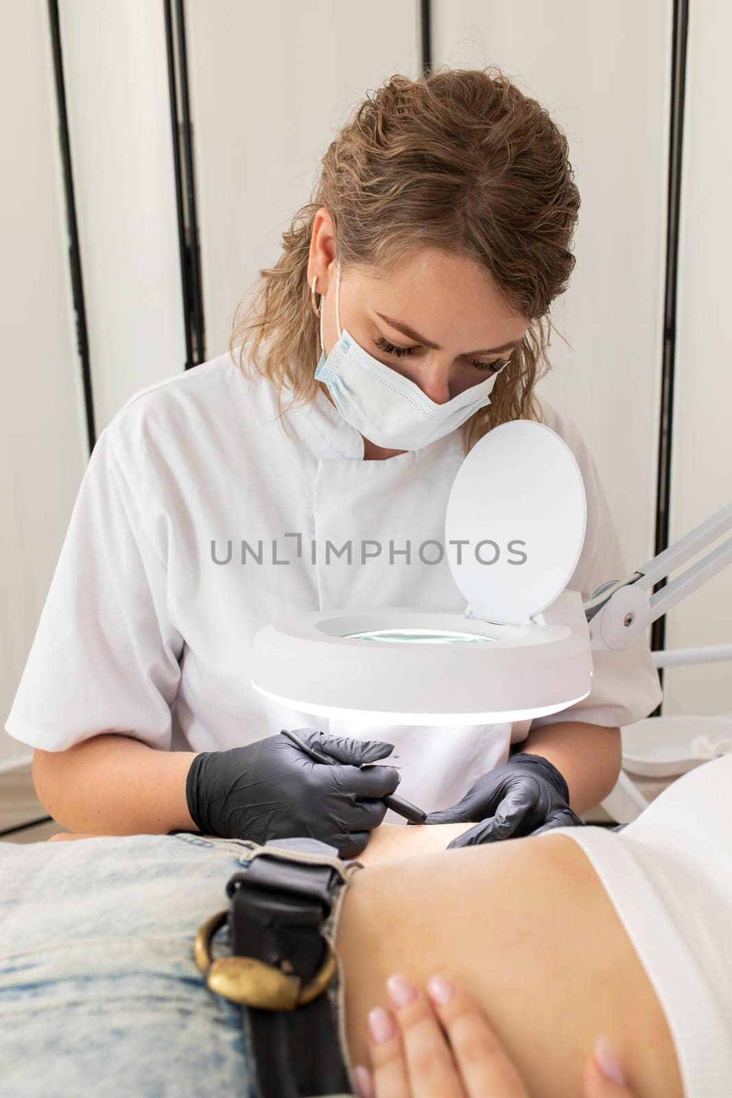 Hair Removal Process With Electrolysis On Hand Of White Young Woman, Cosmetologist Does Electric Epilation In Beauty Salon. Vertical Plane. Authentic High quality photo