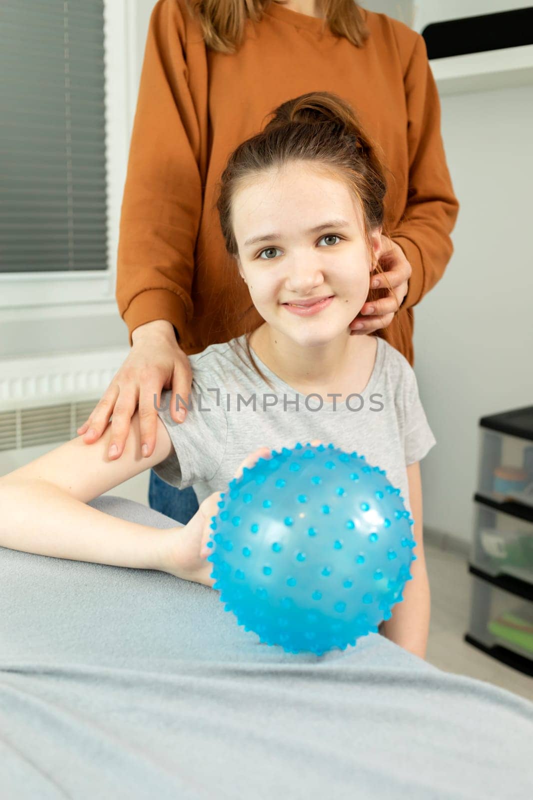 Portrait Of Pretty Smiling Teenager With Disability With Mom Hugging Girl's Shoulders. Caring Loving Parent, Rehabilitation. Balance And Posture Maintenance, Parental Support. Vertical plane.