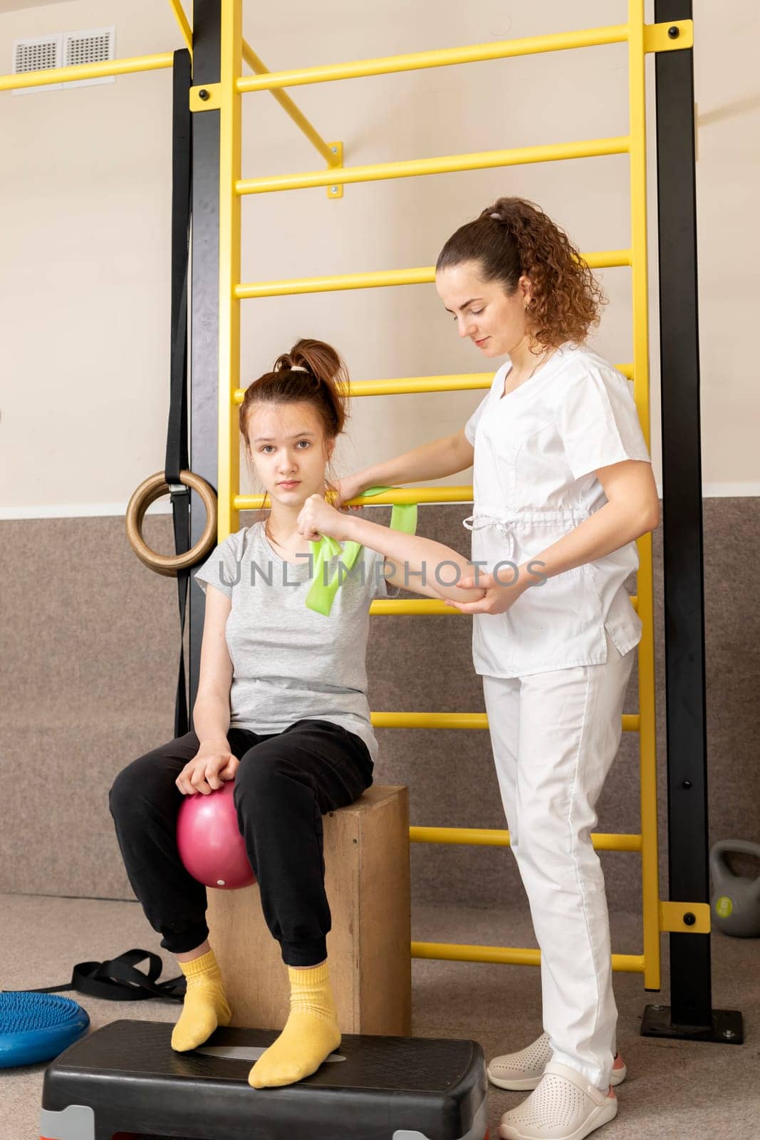 Disabled Child With Doctor Does Physical Exercises In Rehabilitation Room. Kid With Special Needs. Rehabilitation. Cerebral Palsy. Motor Disorder. Vertical plane. High quality photo