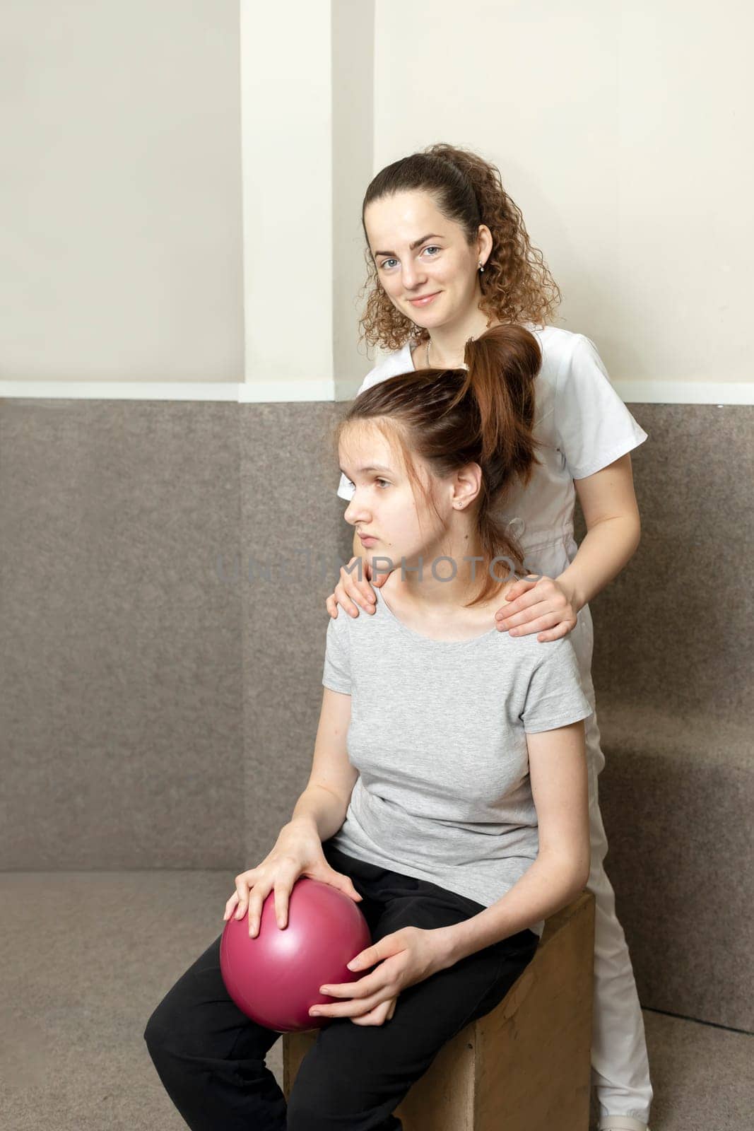 Rehabilitation Specialist, Physical Therapist Hugs Shoulder Of Child, Teenage Girl With Disability. Health Specialist, Rehabilitation. Musculoskeletal Disorder. Vertical plane. High quality photo