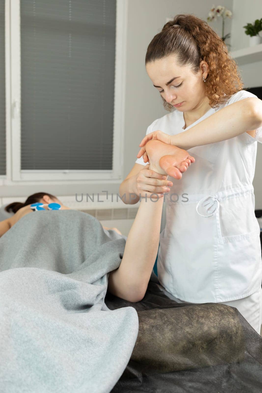 Rehabilitation Specialist, Physical Therapist Makes Foot Massage To Patient With Cerebral Palsy, Scoliosis. Health Specialist, Rehabilitation. Vertical plane. High quality photo