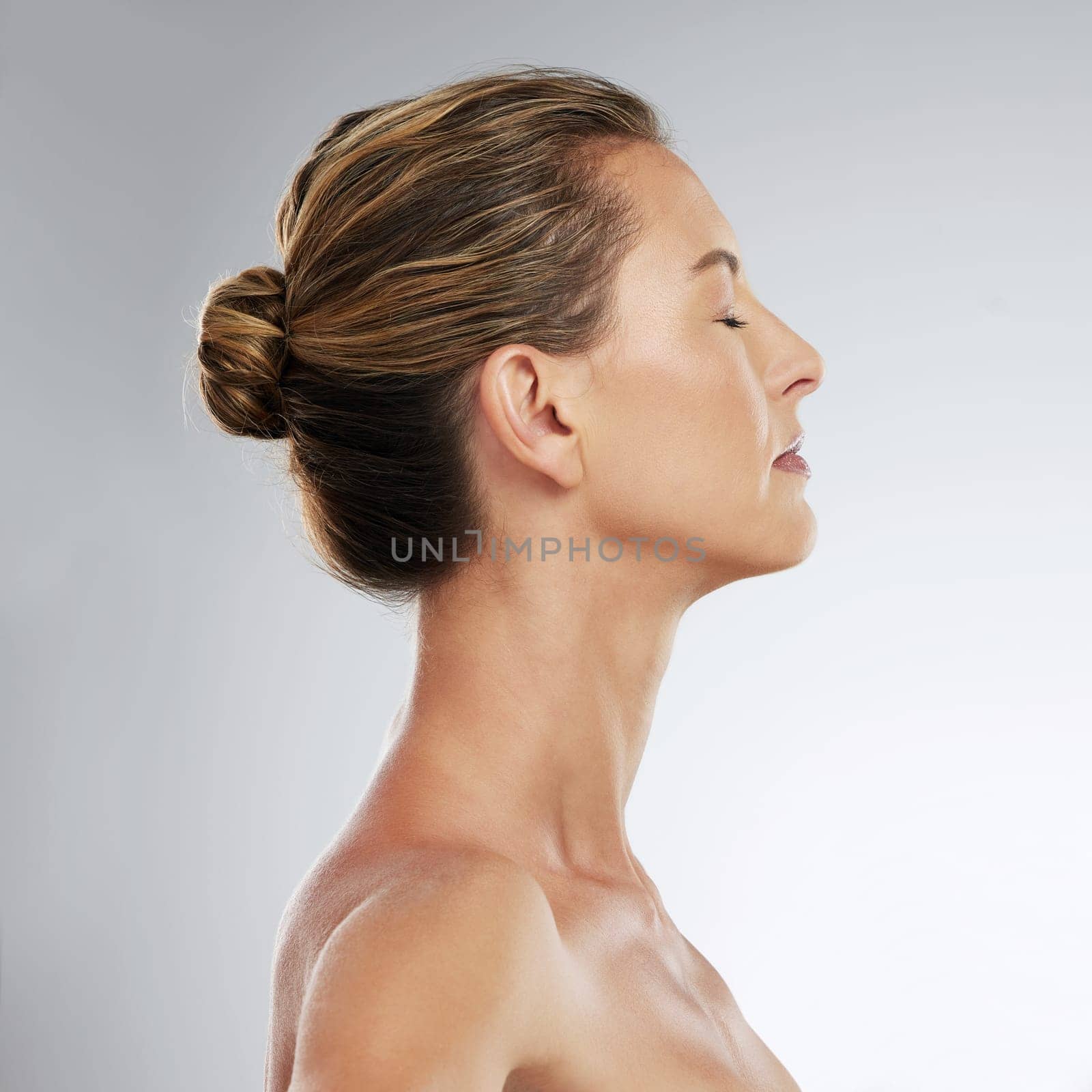 Skincare, beauty and profile of mature woman in studio with a healthy face, skin and face routine. Facial, cosmetic and model with wellness, health and self care lifestyle standing by gray background.