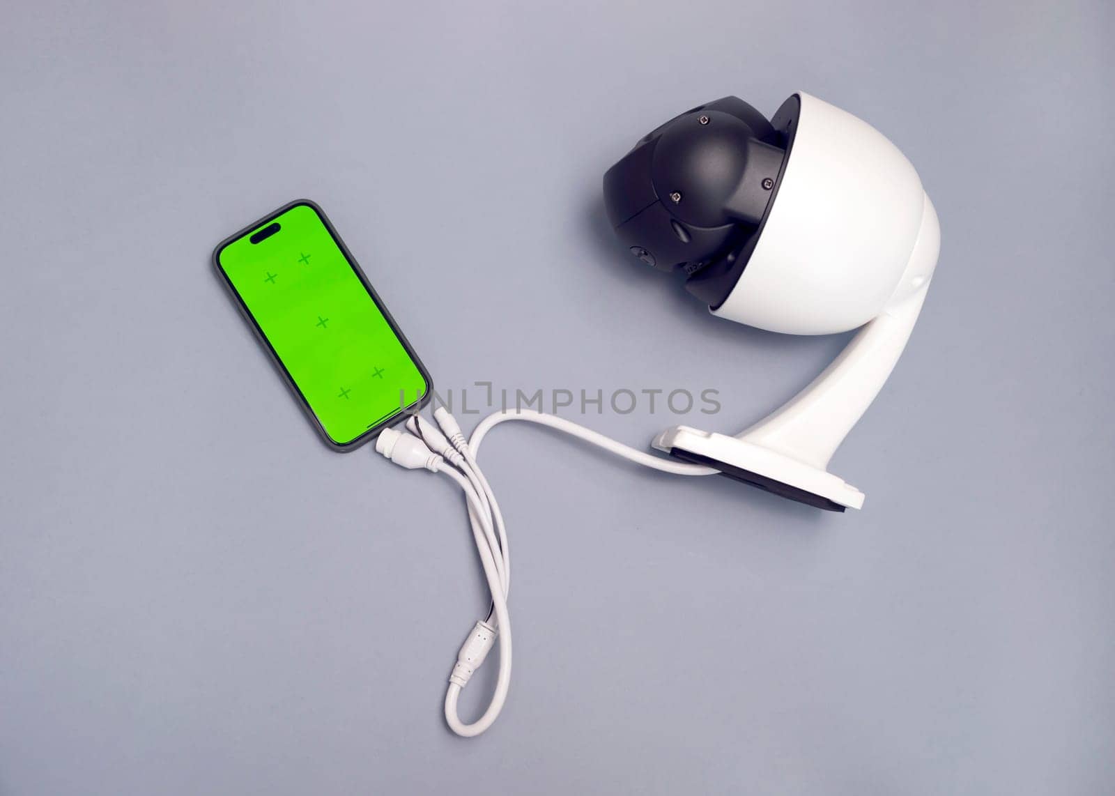Surveillance IP Wireless Camera, Chroma Key Green Screen of Smartphone On Gray Background. Security Equipment For Smart Home,Online Remote App Monitoring.Protection Of Residential Building.Horizontal