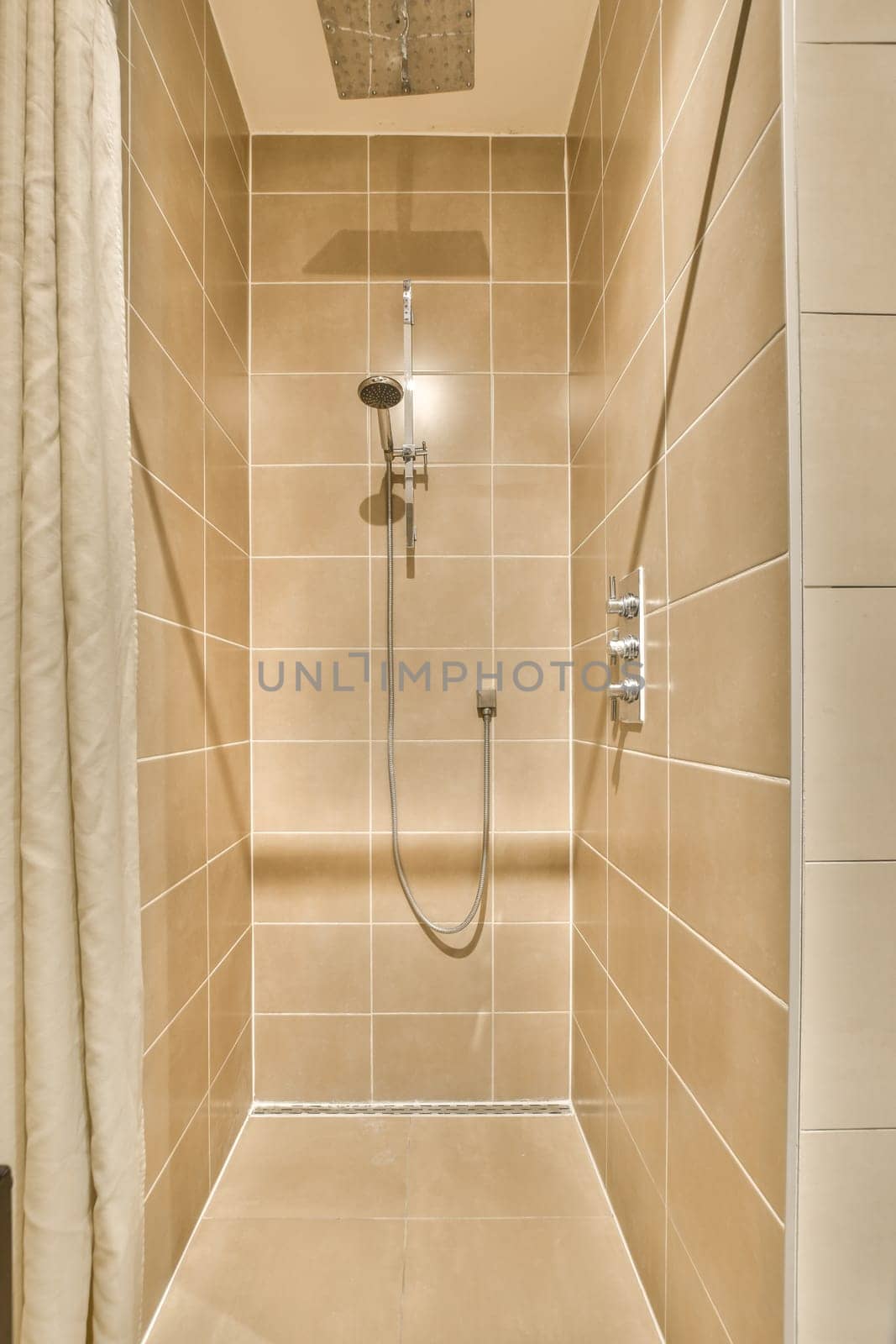 a walk in shower with beige tiled walls and white tiles on the wall behind it is an open shower stall