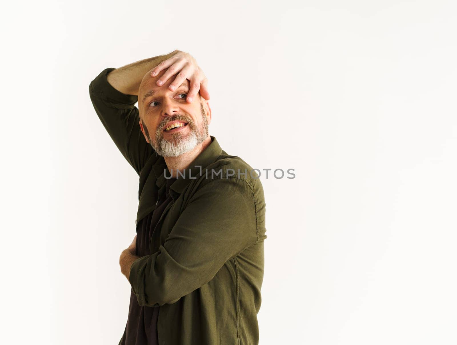 Concept of middle age crisis. Senior man standing against white wall. Mid aged man in pensive pose and looks into future, contemplating uncertainties and challenges that come with life transitions. . High quality photo
