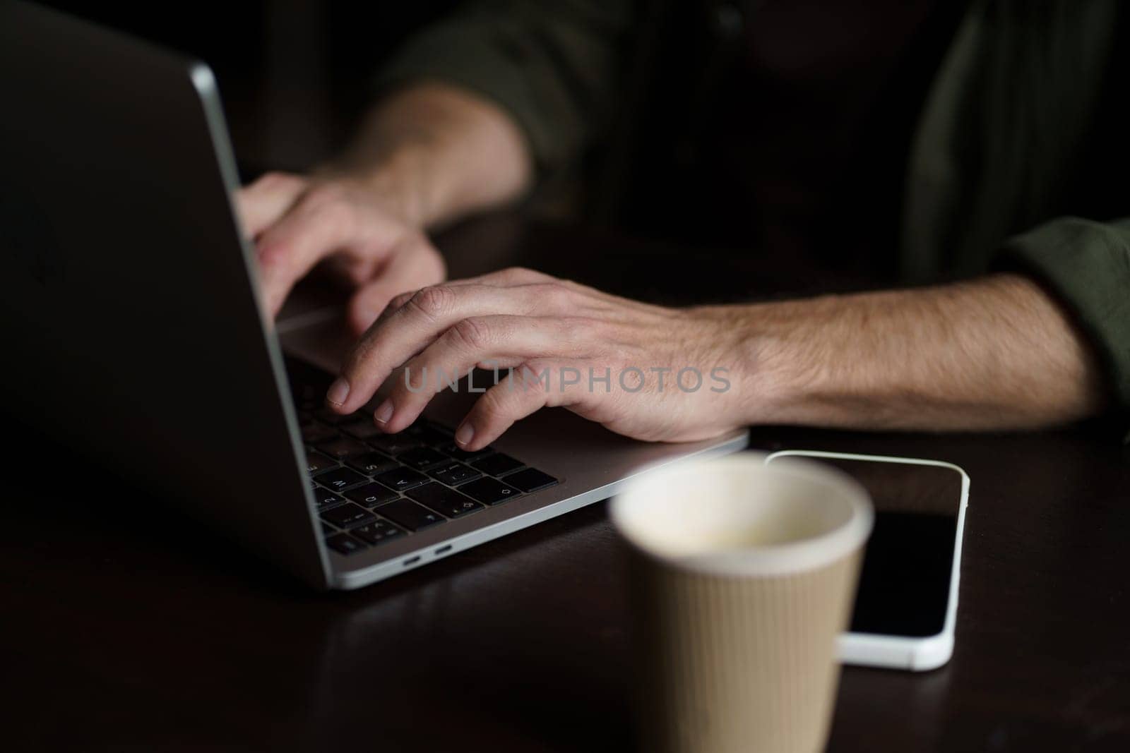 Hands of senior man types message on laptop keyboard. Individuality and essence of senior man's hands, highlighting engagement with technology and digital communication. High quality photo
