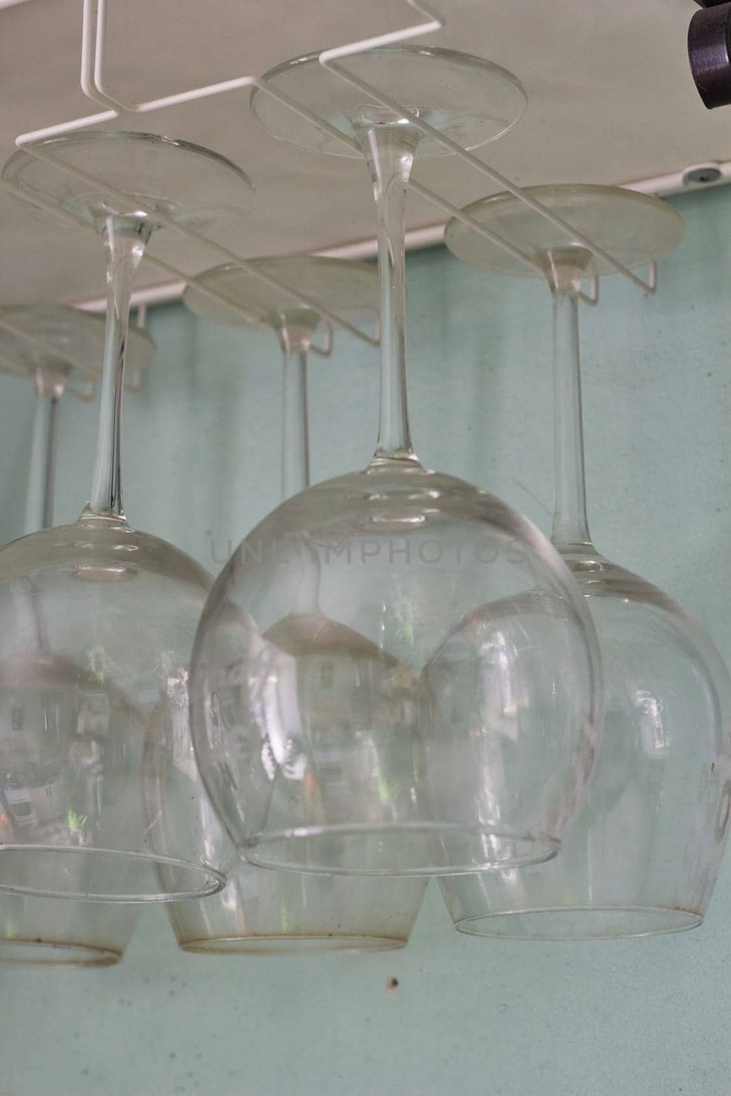 photo overturned wine glasses drying after washing dishes. house cleaner. taking food. alcohol. red and white wine.