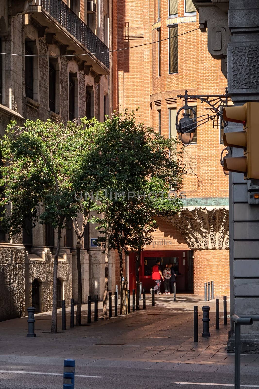 Streets of Barcelona. A view from street Via Laietana to a street with buildings, trees and box office.