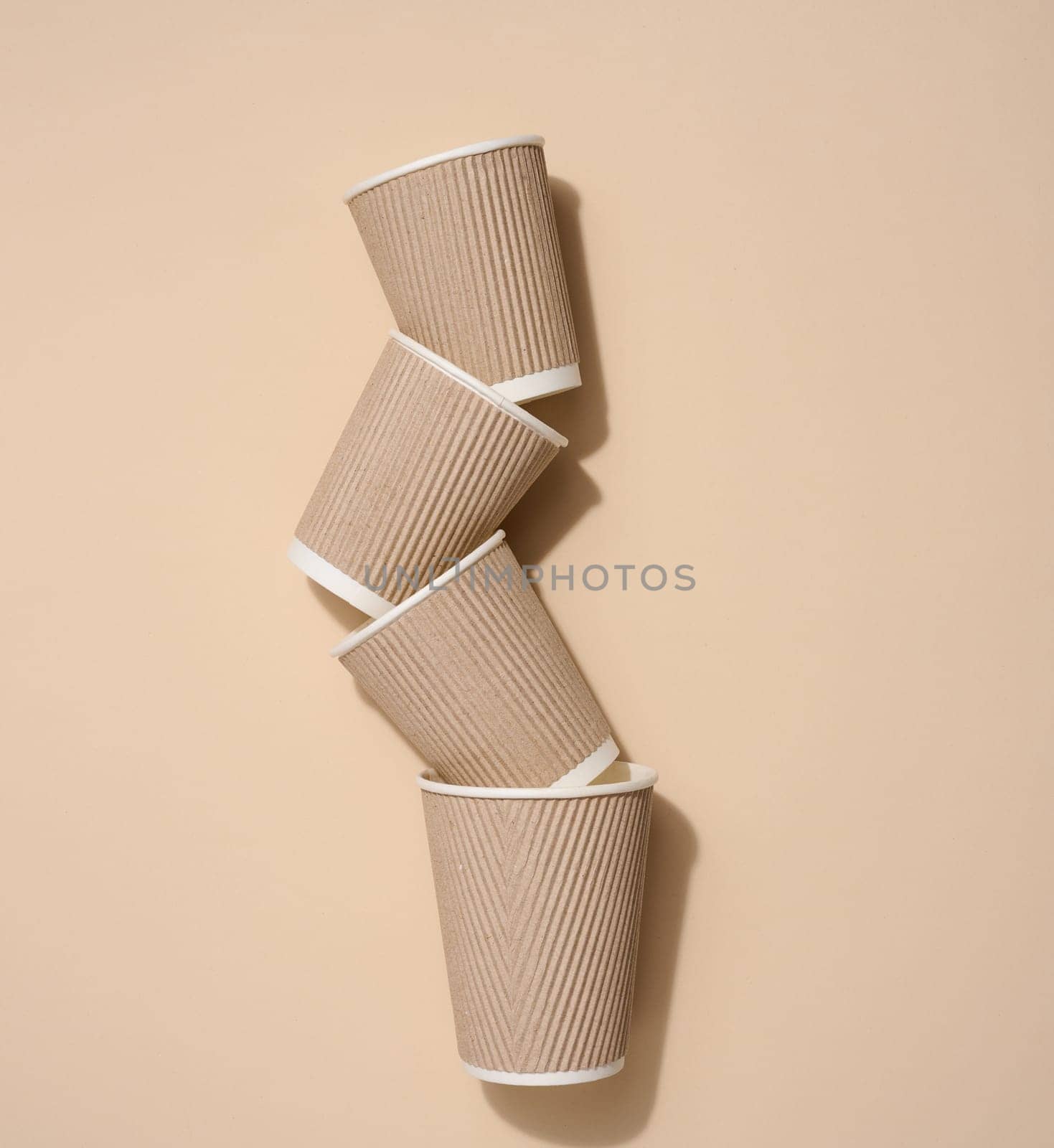 Brown disposable cups for coffee and tea on a beige background, top view by ndanko