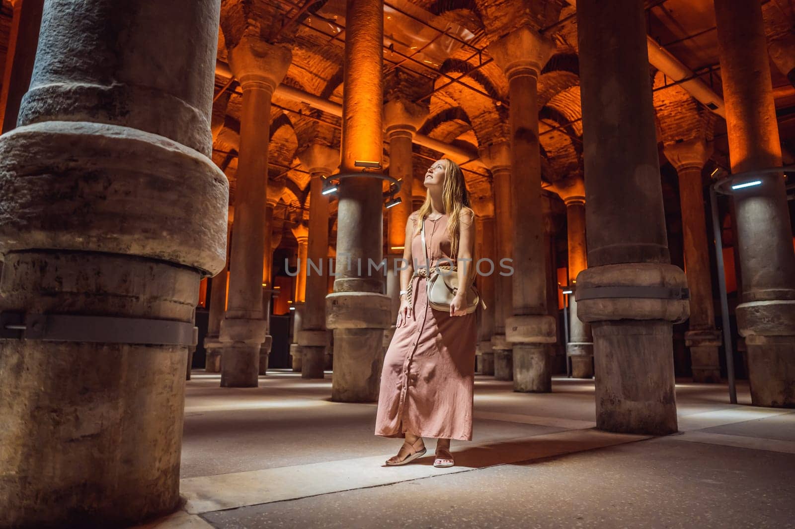 Woman tourist enjoying Beautiful cistern in Istanbul. Cistern - underground water reservoir build in 6th century, Istanbul, Turkey, Turkiye.