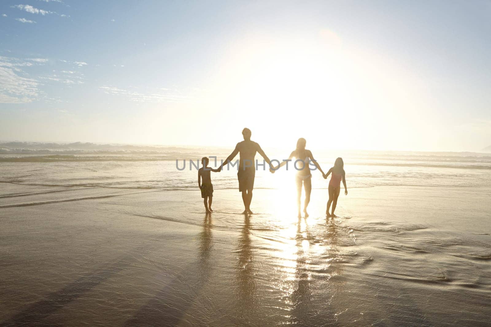 Family in harmony. a family walking on a beach at sunset