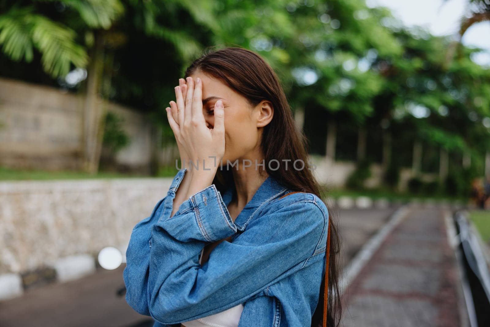 Portrait of a woman brunette smile with teeth walking outside against a backdrop of palm trees in the tropics, summer vacations and outdoor recreation, the carefree lifestyle of a freelance student. by SHOTPRIME