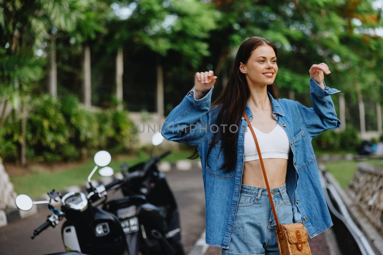 Portrait of a woman brunette smile with teeth walking outside against a backdrop of palm trees in the tropics, summer vacations and outdoor recreation, the carefree lifestyle of a freelance student. High quality photo