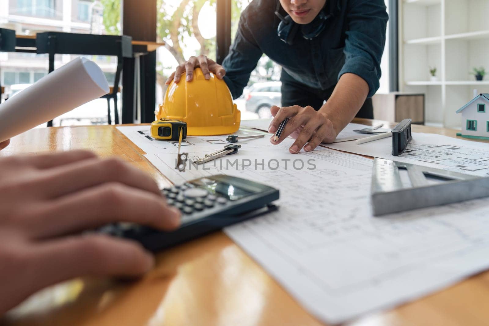 Construction concept of meeting engineers or architects for projects working with partners and engineering tools on modeling and blueprint design in office.