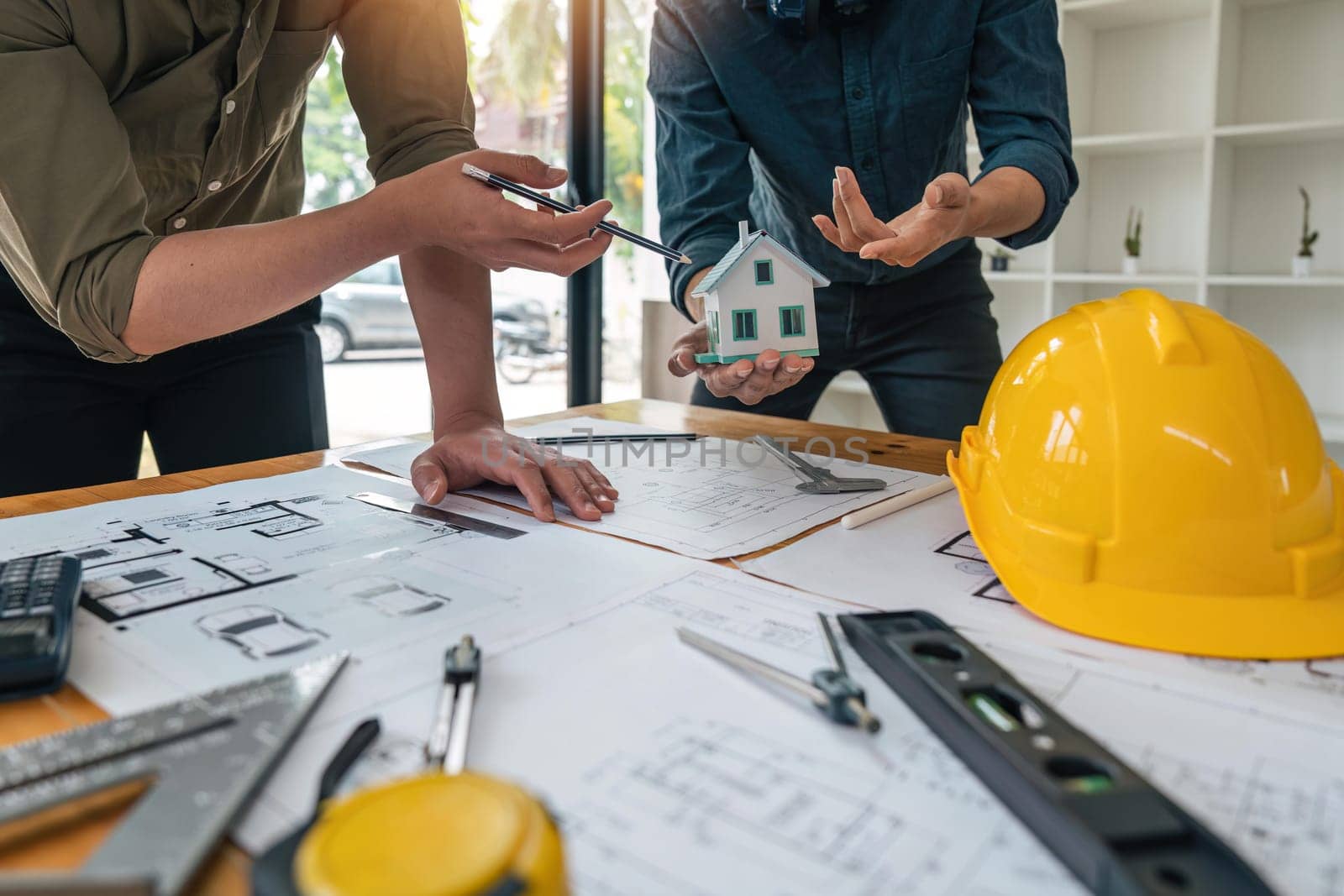 Construction concept of meeting engineers or architects for projects working with partners and engineering tools on modeling and blueprint design in office.