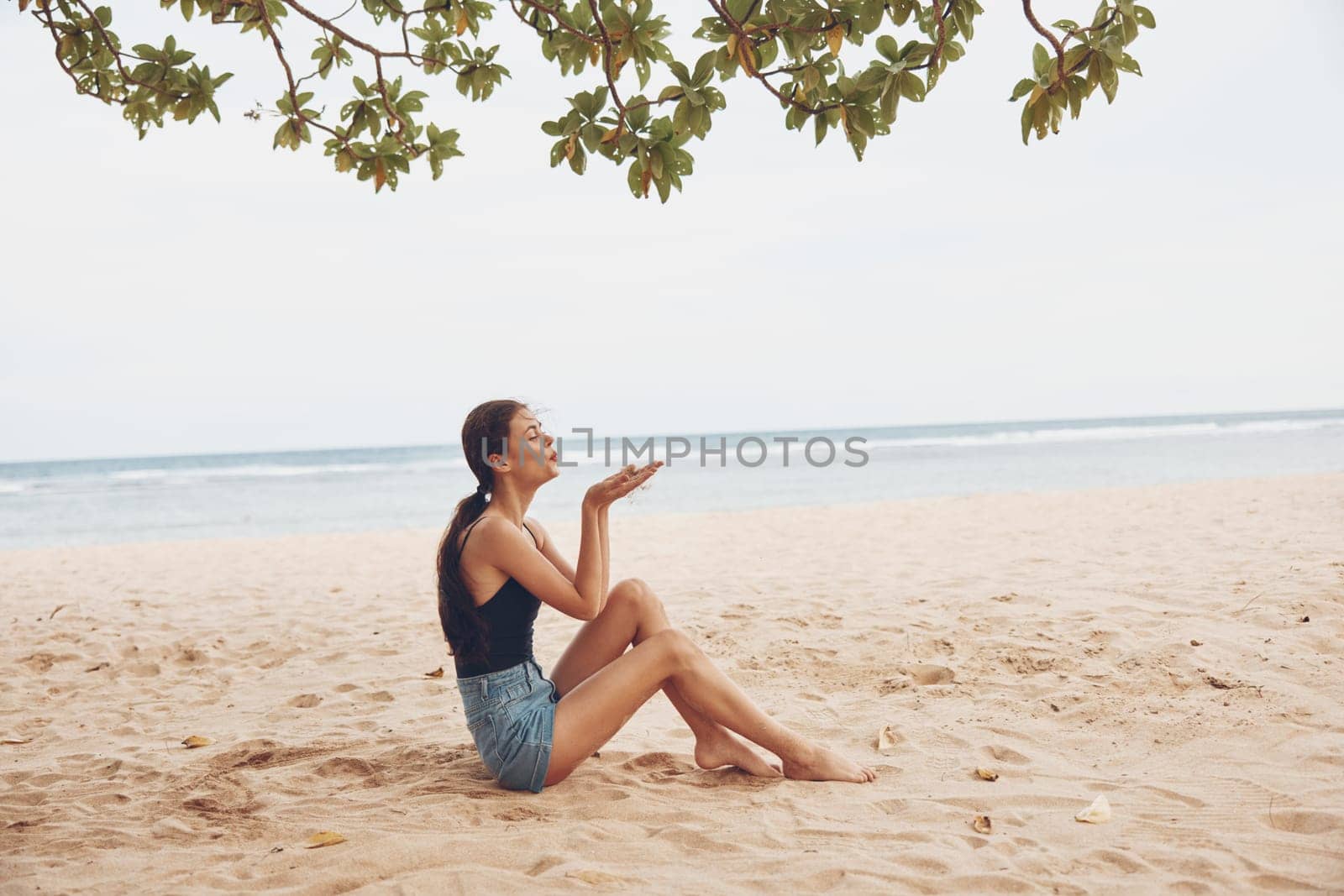 carefree woman vacation fashion sitting sand smile pretty long beach model young adult sea freedom beauty body nature caucasian hair travel holiday