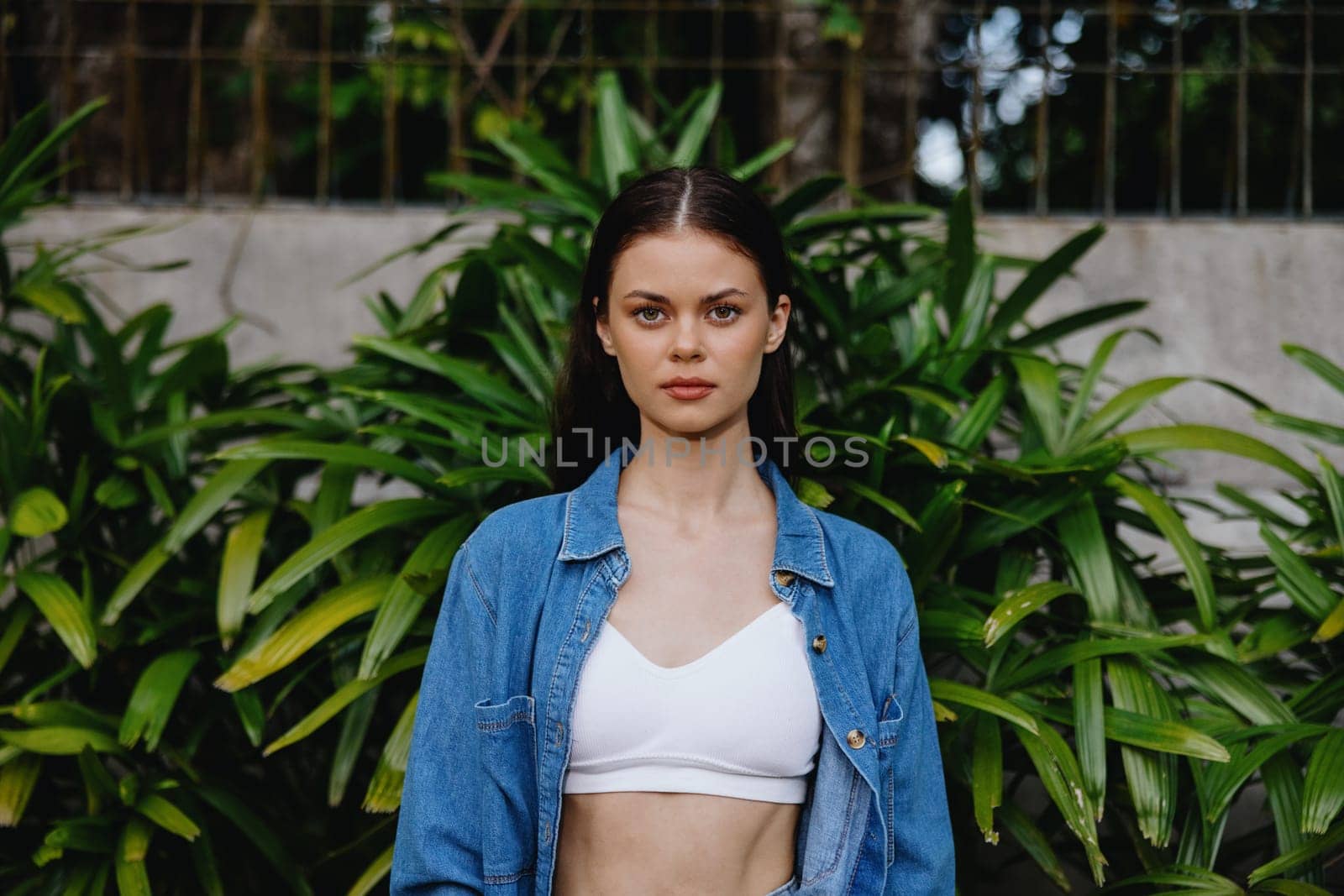 Portrait of a woman against a backdrop of palm trees in the tropics, summer vacations and holidays by SHOTPRIME