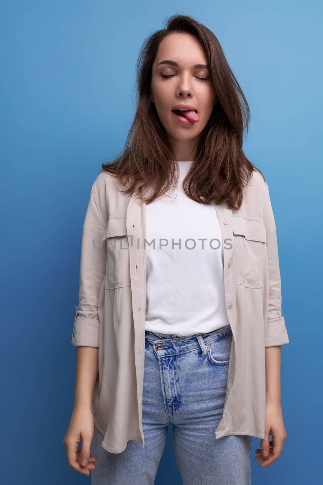 cheerful 30s brunette woman dressed in a shirt with a grimace.