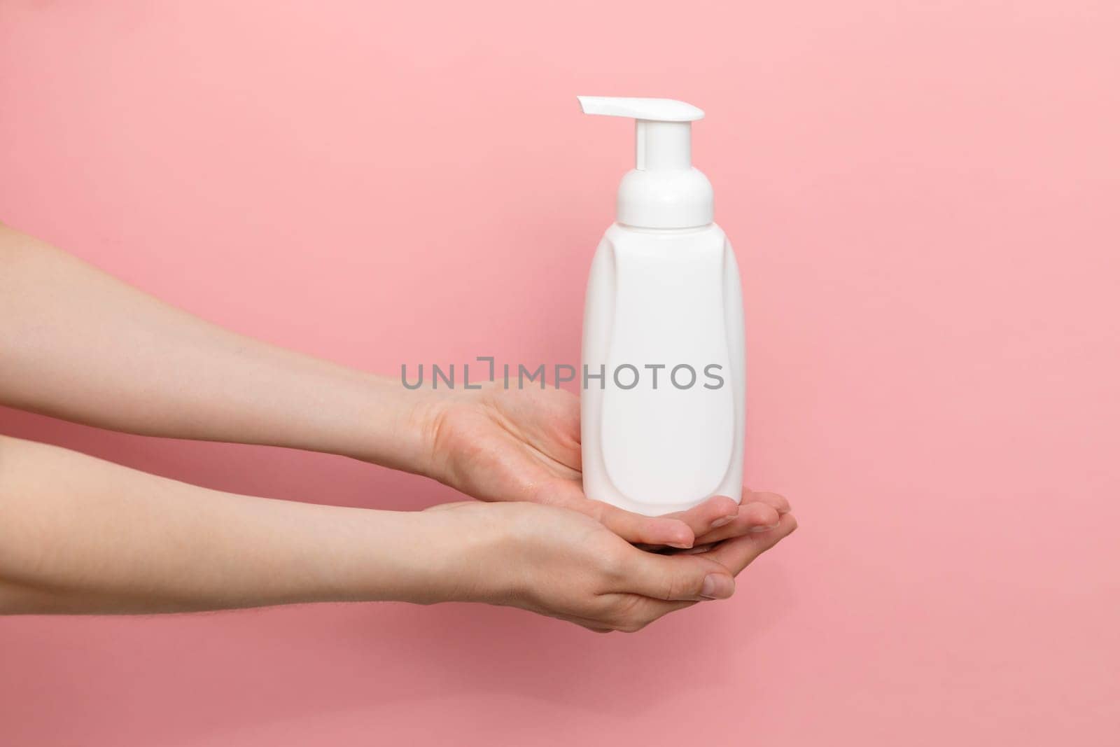Female Hands Holding Blank White Dispenser Bottle, Plastic Tube On Pink Background. Hygiene, Cosmetic Beauty Product, Washing, Cleansing Intimate Gel, Foam. Daily Body Care. Horizontal Plane, Closeup.