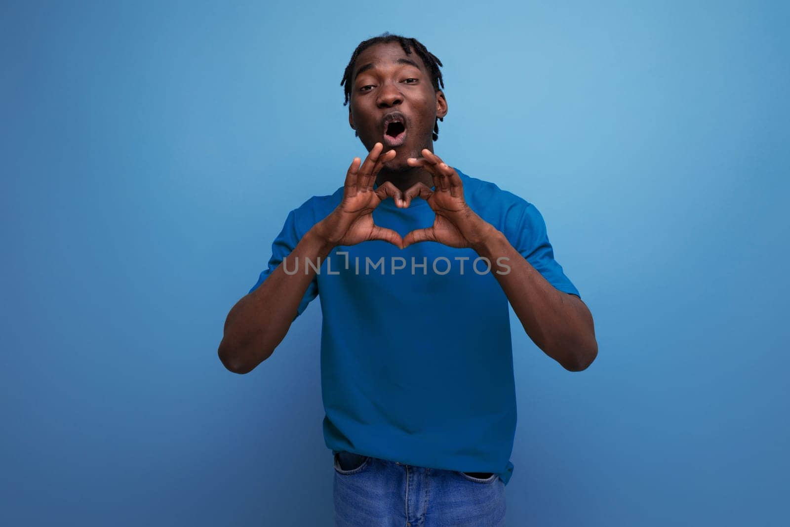 kind loving american young man with dreadlocks in a casual t-shirt against the background with copy space by TRMK