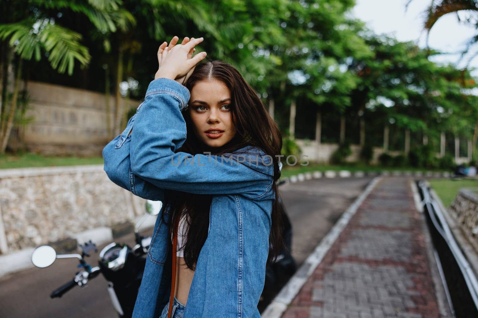 Portrait of woman brunette smile with teeth running down the street against backdrop palm trees in the tropics, summer vacations and outdoor recreation, the carefree lifestyle of a freelance student. by SHOTPRIME