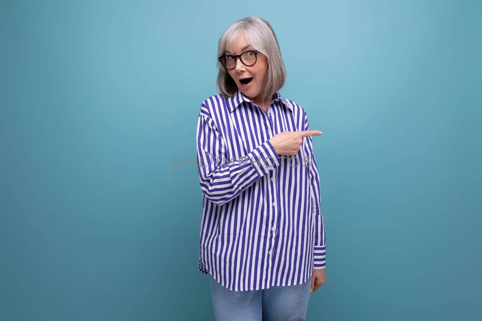 surprised middle-aged youth lady with gray hair on a bright studio background with copy space.