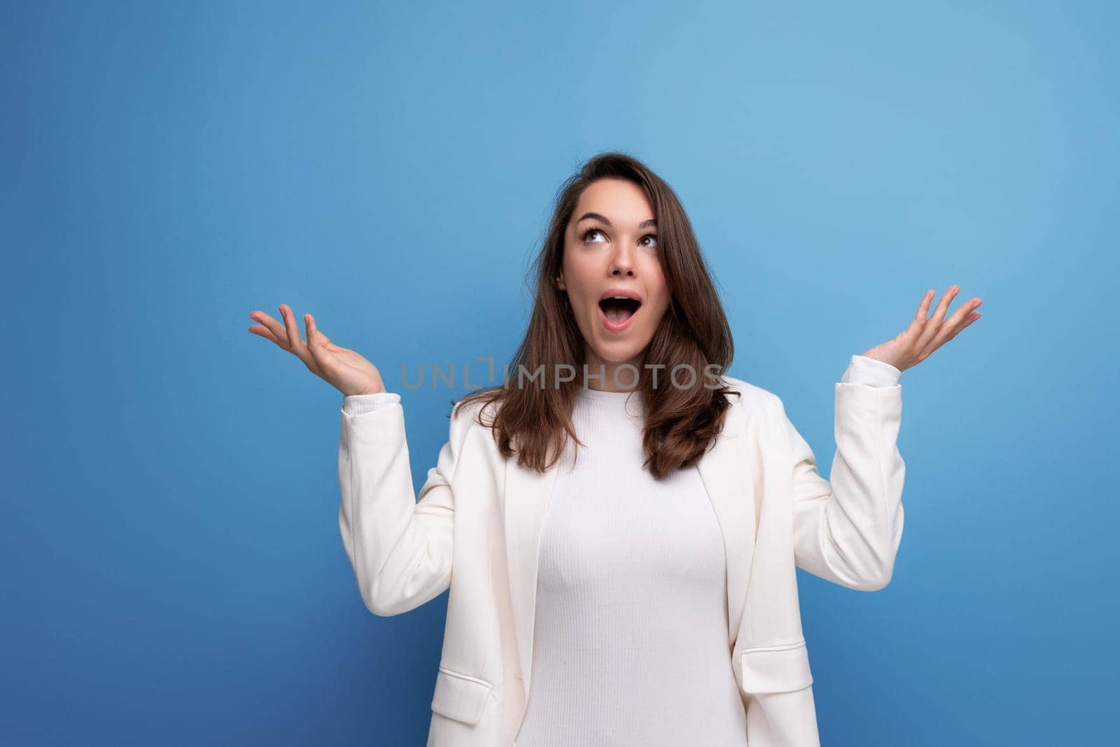 lucky happy brunette woman in dress on studio background with copyspace.