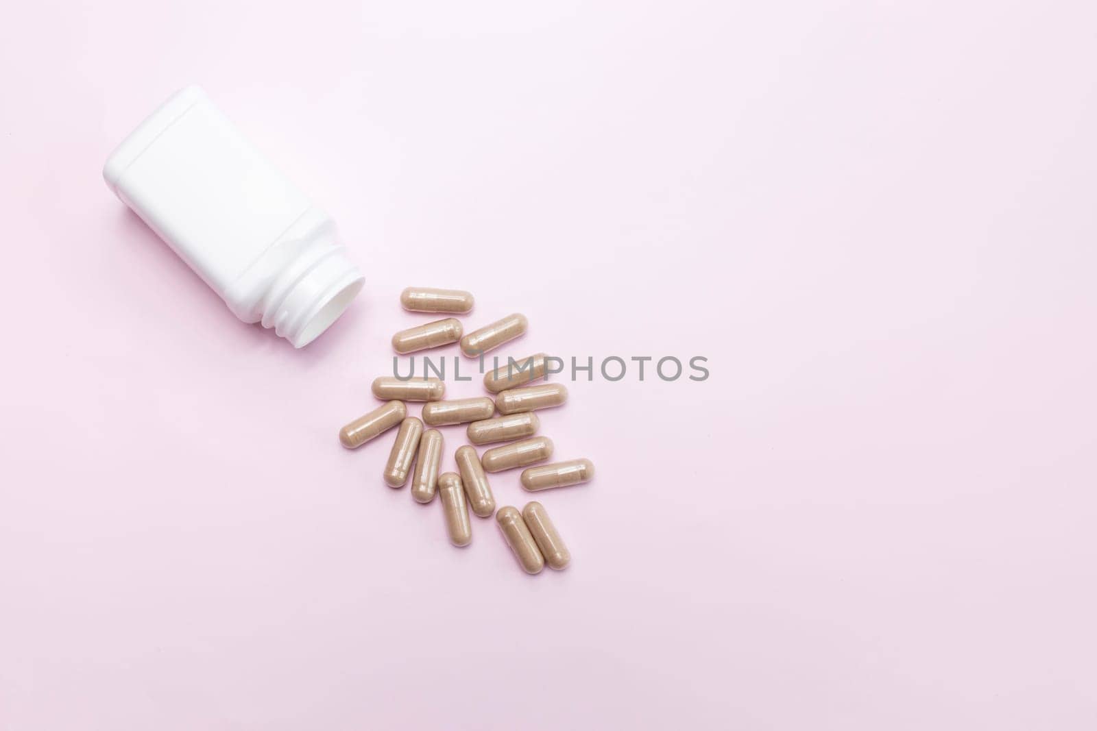 Scattered Tablets, Capsules OF Slippery Elm, White Bottle, Container On Pink Background. Dietary Nutritional Supplement, Medication. Ulmus Fulva, Herbal Remedy Concept. Horizontal,Copy space For Text