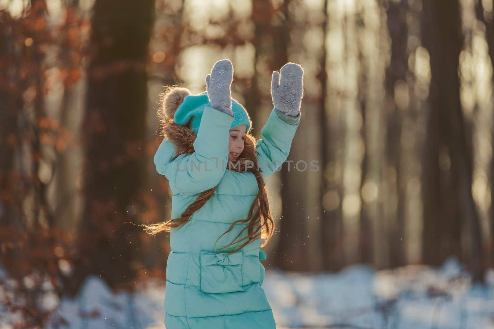 portrait of a girl against the backdrop of a winter forest illuminated by the sun