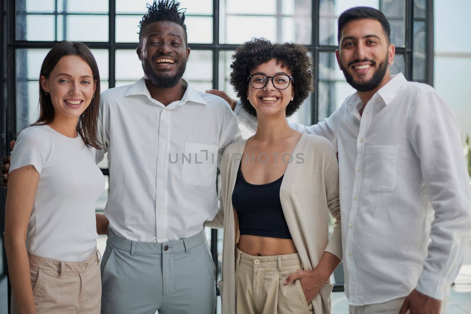 Portrait of successful creative business team looking at camera and smiling. Diverse business people standing together at startup.