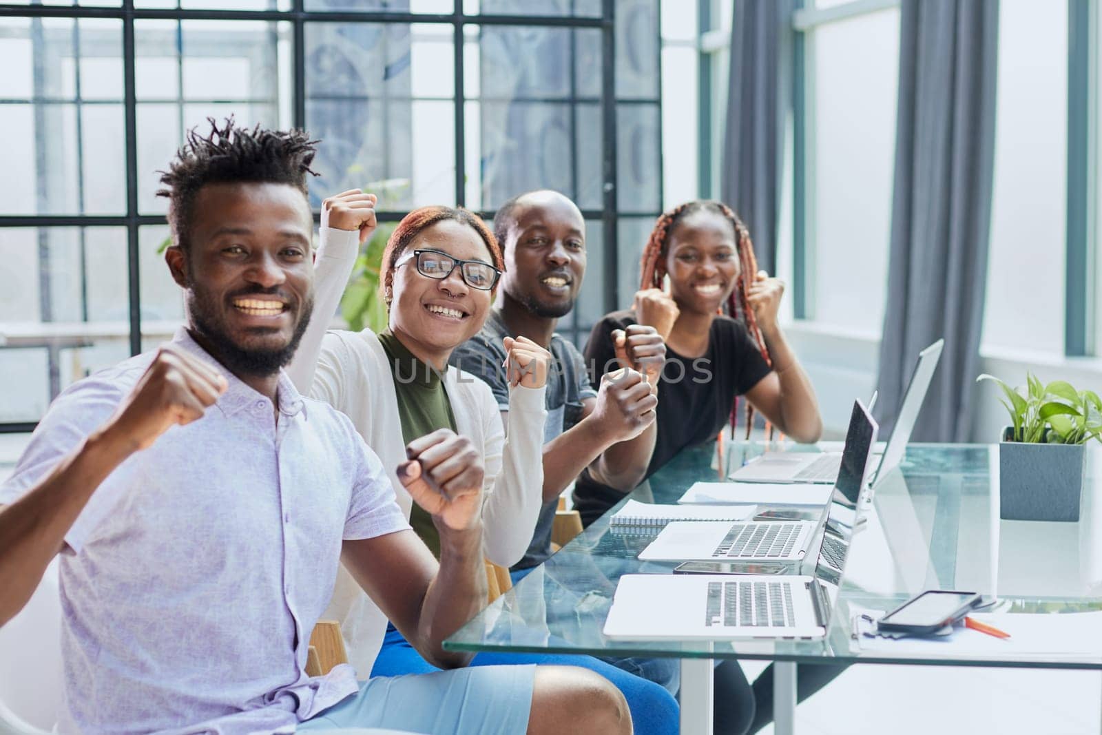 Happy young African-American man and his team in background