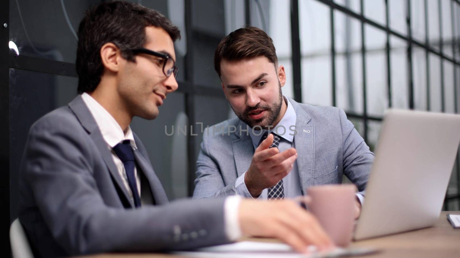 Young designer giving some new ideas about project to his partners in conference room