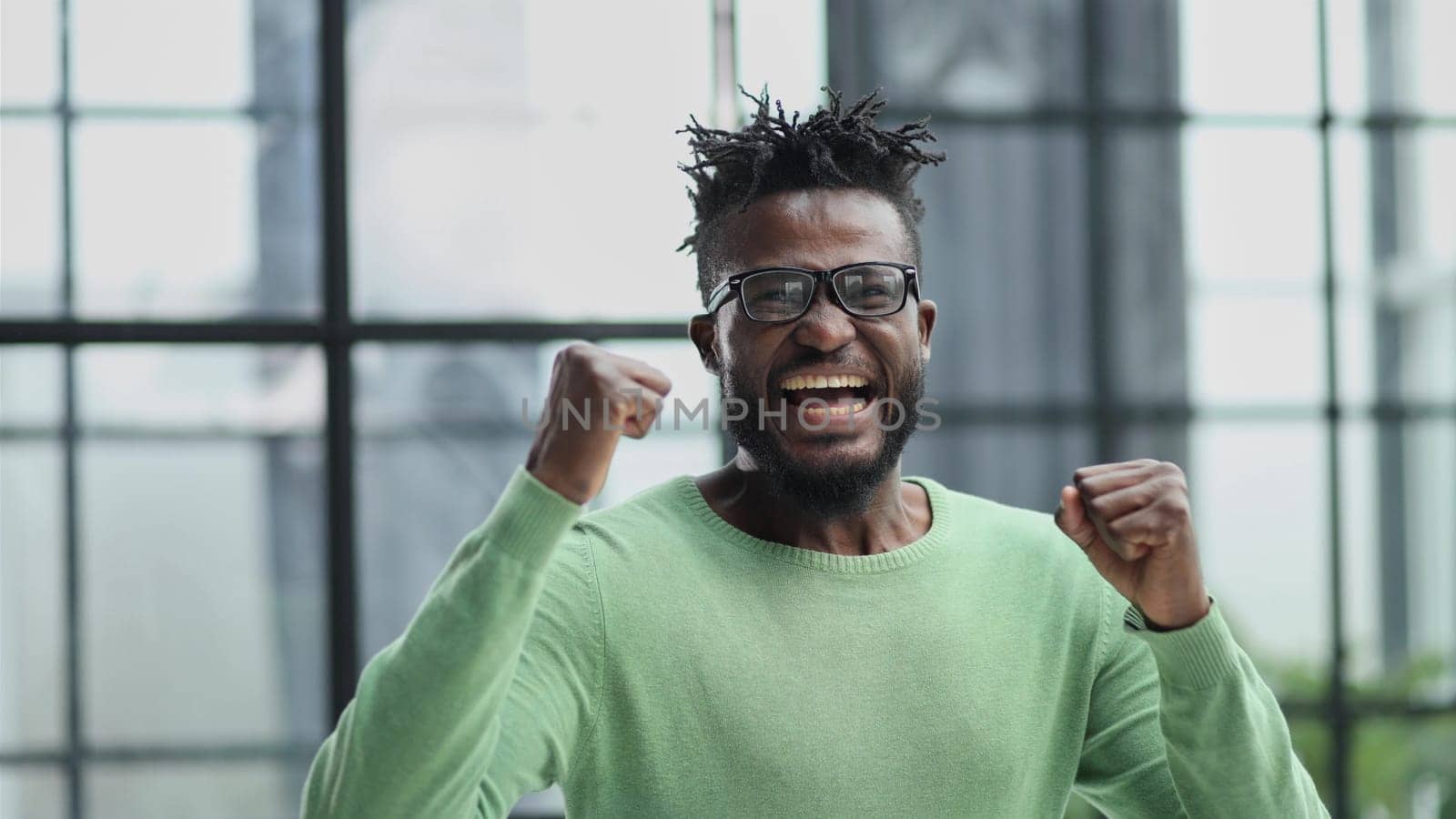 Excited young man african american businessman shouting loudly and expressively gesturing with his hands