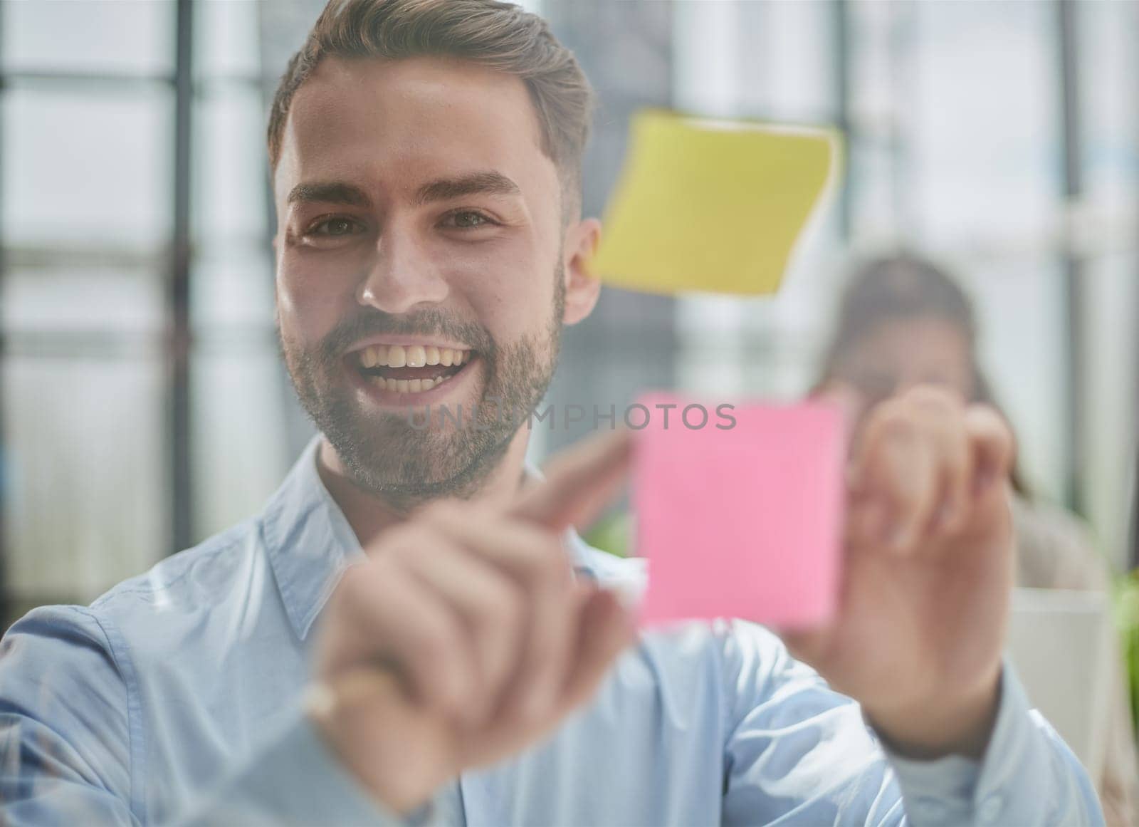 businessman is working on a project. Business man pointing at a note on the glass wall