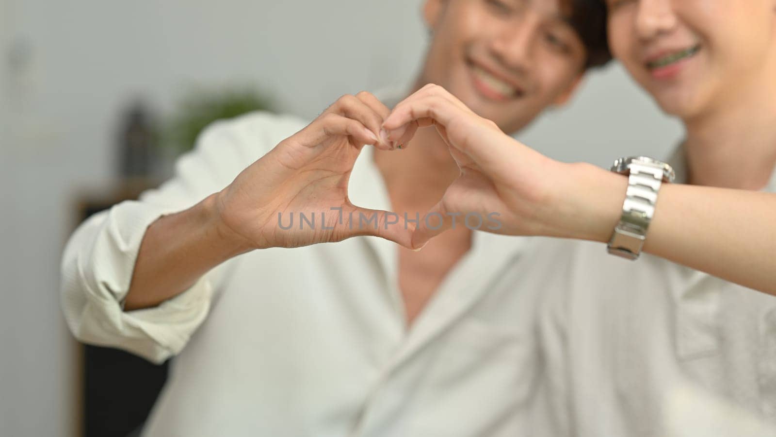 Affectionate same sex male couple making heart with their hands. LGBT, love and lifestyle relationship concept by prathanchorruangsak